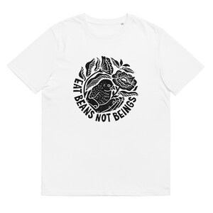May include: White t-shirt with a black print of a bird in a floral design. The text around the bird reads "Eat Beans Not Beings."