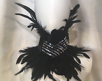 May include: A black feather choker with silver sequins. The choker is on a white mannequin bust. The text "Dellton Couture" is visible in the bottom right corner of the image.