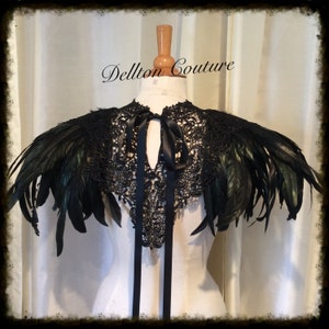 May include: Black lace and feather shoulder piece with a black satin ribbon tie.  The piece is on a white dress form.  The text "Dellton Couture" is visible in the image.