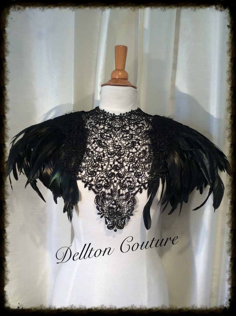 May include: Black lace collar with black feather shoulder pieces. The collar is a delicate lace design and the feathers are soft and fluffy. The collar is on a white mannequin. The text "Dellton Couture" is at the bottom of the image.