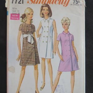 May include: A vintage Simplicity 7721 sewing pattern envelope featuring illustrations of three dresses. The left dress is brown with a white grid pattern and a sash. The center dress is white, and the right dress is light purple. All have buttons.