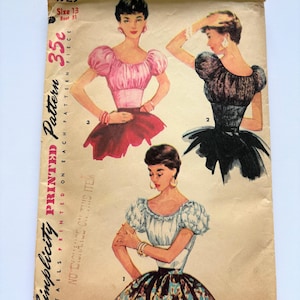 May include: A vintage Simplicity printed pattern envelope, number 4929, size 13, bust 31. The tan paper envelope features illustrations of three different blouse and skirt outfits with puff sleeves, including a pink, black, and white design.