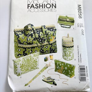 May include: McCall's Fashion Accessories sewing pattern M6256 for bags and pouches. The envelope displays illustrations of a large green and black floral tote, a tall cylindrical bag, two rectangular pouches with damask patterns, and small accessories.