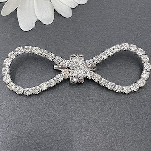 2 Broscher med platta baksidor och strassknappar och rosett (55*28 mm)