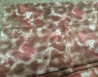 May include: A brown and pink fabric with a floral pattern. The fabric has a speckled texture and features a repeating pattern of pink flowers with white centers and brown stems.