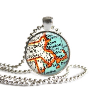 May include: A silver chain necklace with a round pendant featuring a vintage map of Massachusetts. The map is in shades of orange, blue, and green, with the city of Boston highlighted in orange.