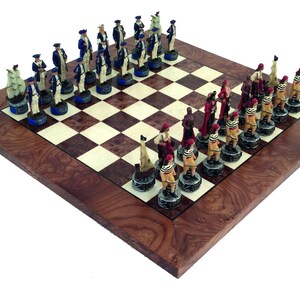 May include: A detailed chess set with a wooden board and intricately designed pieces. The pieces are painted in various colors, including blue, red, and tan, and are arranged on a checkered board. The board has a dark wood border.