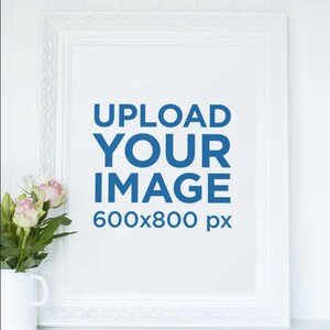 Peut inclure: Cadre photo blanc avec un passe-partout blanc et un texte bleu superposé qui dit "UPLOAD YOUR IMAGE 600x800 px". Un bouquet de roses roses est dans une tasse blanche à gauche du cadre.