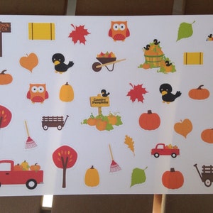 May include: A sheet of fall-themed stickers featuring pumpkins, owls, leaves, and a scarecrow. Other images include a red truck, a wagon, and a sign that says "Pumpkin Patch". The stickers are in shades of orange, yellow, and brown.