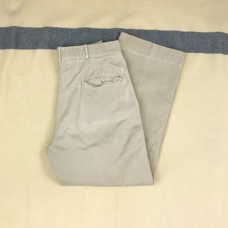 May include: A pair of light beige casual pants with a single back pocket.