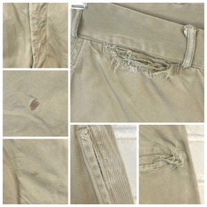 May include: A pair of light brown pants with distressed details. The pants have several small holes and tears, and there are a few brown stains on the fabric.