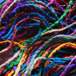 May include: A collection of colorful, twisted silk threads in various shades of blue, green, orange, pink, purple, and brown.