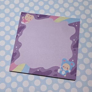 Può includere: Blocco note viola con un bordo arcobaleno e due animali dei cartoni animati, uno rosa e uno blu, negli angoli. Il blocco note ha uno sfondo bianco con un bordo viola e un bordo arcobaleno.