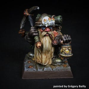 May include: Miniature fantasy figure of a dwarf miner, holding a pickaxe and a lantern. The dwarf has a long, cream-coloured beard, a helmet with a candle, and a backpack. The figure is painted with detailed shading and sits on a stone base.