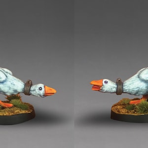 Pode incluir: Uma figura fantasiosa de um ganso com penas azuis e brancas, bico e pés laranja e uma coleira castanha. O ganso está montado numa pequena base redonda com relva verde e terra castanha.