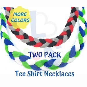 May include: Two braided tee shirt necklaces in a two-pack. One necklace features blue, green, and white, while the other has red, black, and gray. The image includes the text "More Colors" and "Tee Shirt Necklaces."