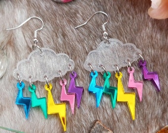 May include: A pair of silver earrings with a cloud charm and iridescent lightning bolt charms hanging from the bottom. The charms are in various colors, including pink, blue, yellow, and green.