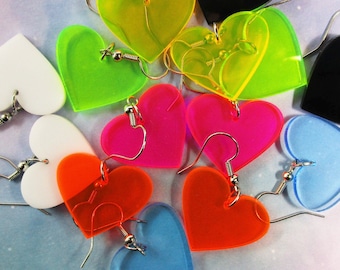 May include: A collection of heart-shaped earrings in various colors including neon yellow, bright pink, orange, light blue, white, and black. Each earring features a silver-toned metal hook for attachment, showcasing a smooth, flat acrylic finish.