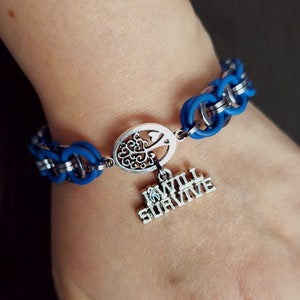 May include: A blue and silver bracelet with a charm that says "I Will Survive" and a tree design.