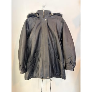 May include: Black leather jacket with a fur-trimmed hood. The jacket features a zipper closure, two front pockets, and a drawstring at the waist. The sleeves have buttoned cuffs.