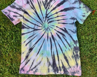 May include: A tie-dye t-shirt with a black, blue, yellow and pink swirl pattern.