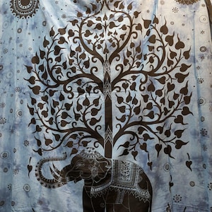 May include: A blue tapestry with a brown elephant and tree design. The elephant is detailed with ornate patterns and stands beneath a tree with heart-shaped leaves. The background has a tie-dye effect with circular and star patterns.