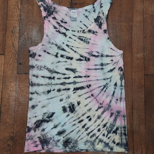 Könnte beinhalten: Ein Batik-Tanktop mit einem schwarzen, rosa und blauen Wirbelmuster. Das Tanktop ist aus einem weichen, bequemen Stoff gefertigt und hat eine lockere Passform.