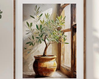 May include: A framed painting of an olive tree in a terracotta pot, set by a window. The artwork is in a wooden frame and is part of a cozy interior design scene. A wooden chair with a blanket and a wooden cabinet are also visible.
