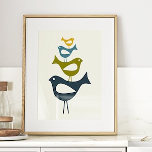 May include: A framed art print featuring a stack of stylized birds in shades of blue, green, and yellow. The artwork is displayed in a kitchen setting, with a light wood frame and a white mat. The print adds a touch of modern art to the space.