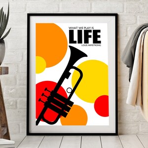 May include: A black and white poster with a quote by Louis Armstrong, "What we play is life." The poster features a black silhouette of a trumpet against a background of red, orange, and yellow circles.