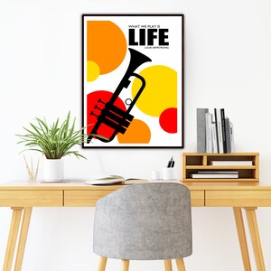 May include: A black and white poster with a trumpet and colorful circles. The text on the poster reads "What we play is life" and "Louis Armstrong".