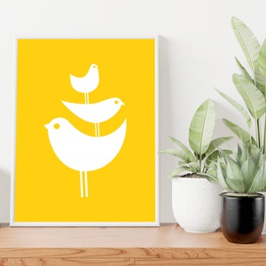 May include: A white framed print with a yellow background and three white stylized birds stacked on top of each other.
