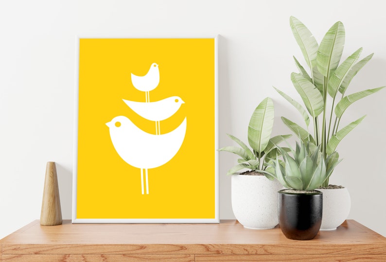 May include: A white framed print with a yellow background and three white stylized birds stacked on top of each other.