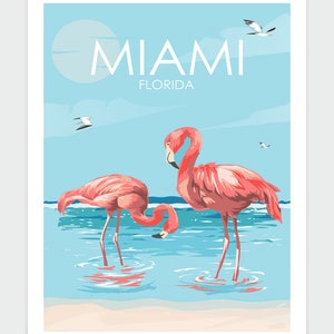 K&ouml;nnte beinhalten: Ein Vintage-Reiseposter mit zwei rosafarbenen Flamingos, die im blauen Wasser stehen, mit einem Sandstrand im Vordergrund. Das Poster hat einen blauen Himmel mit wei&szlig;en Wolken und den Text "MIAMI FLORIDA" oben.