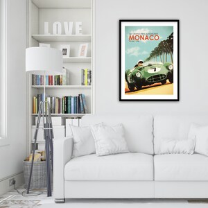 May include: A vintage poster for the 14th Grand Prix Automobile de Monaco, held on May 18, 1958. The poster features a green race car speeding down a road lined with palm trees.