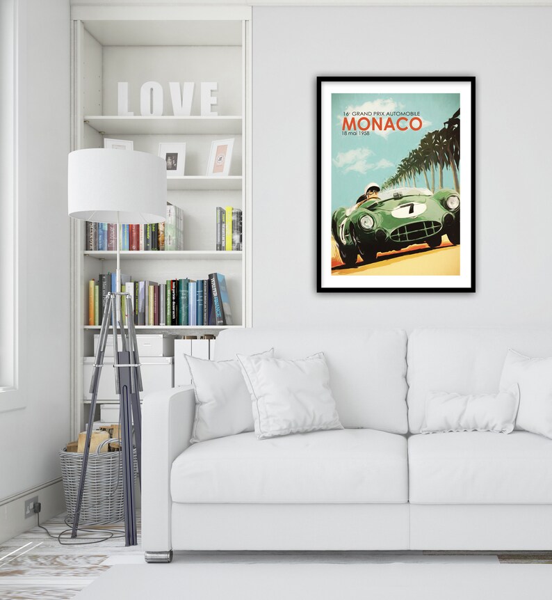 May include: A vintage poster for the 14th Grand Prix Automobile de Monaco, held on May 18, 1958. The poster features a green race car speeding down a road lined with palm trees.
