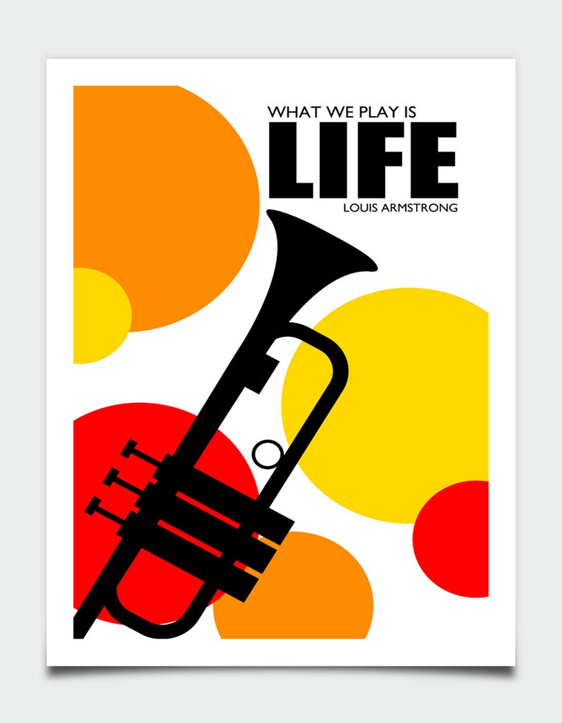 May include: A black trumpet with a red, orange, and yellow circle pattern in the background. The text "WHAT WE PLAY IS LIFE" and "LOUIS ARMSTRONG" is printed in black.