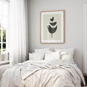 Pu&ograve; includere: Un letto bianco con un copripiumino bianco e cuscini bianchi. Una stampa incorniciata di tre uccelli neri su sfondo beige &egrave; appesa al muro dietro il letto.