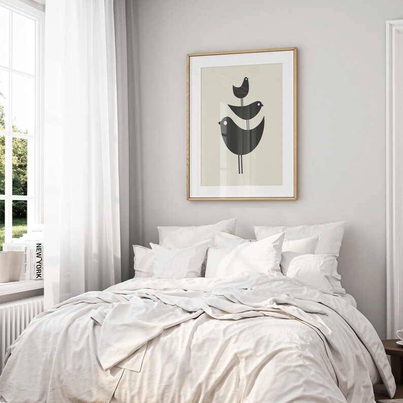 Pu&ograve; includere: Un letto bianco con un copripiumino bianco e cuscini bianchi. Una stampa incorniciata di tre uccelli neri su sfondo beige &egrave; appesa al muro dietro il letto.