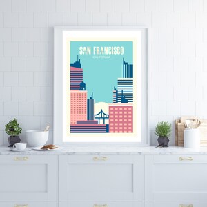 May include: A framed poster with a minimalist design depicting the San Francisco skyline in pink, blue, and white. The text "SAN FRANCISCO, CALIFORNIA" is at the top of the poster.
