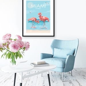 K&ouml;nnte beinhalten: Ein Poster mit blauem Hintergrund und wei&szlig;en Wolken. Der Text "MIAMI FLORIDA" befindet sich oben auf dem Poster. Zwei rosafarbene Flamingos stehen im Wasser.