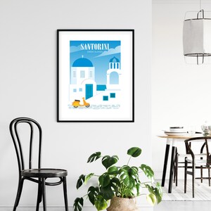 May include: A black framed print with a colorful illustration of a white building with a blue dome, a yellow scooter, and the text "Santorini Greek Islands".