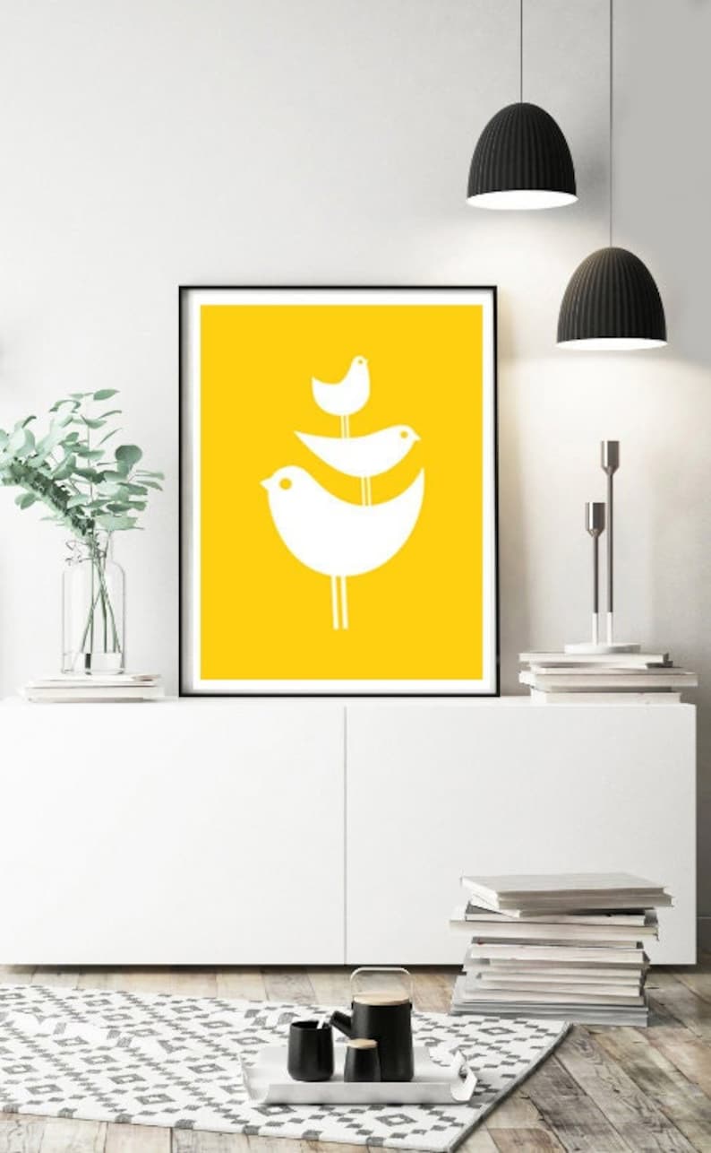May include: A framed print with a yellow background and three white stylized birds stacked on top of each other.