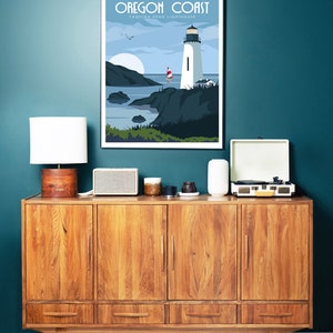 May include: A vintage-style wooden cabinet with four doors and three drawers. The cabinet is decorated with a framed poster that reads "Oregon Coast Yaquina Head Lighthouse". The poster features a lighthouse on a rocky coastline with a sailboat in the distance.