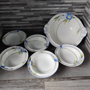 May include: Set of six white ceramic bowls with blue and green floral designs. The bowls are various sizes and include a large serving bowl.