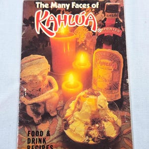 May include: A vintage cookbook cover titled "The Many Faces of Kahlúa" with a bottle of Kahlúa, lit candles, a dessert, and a small statue. The cover features the words "Food & Drink Recipes".