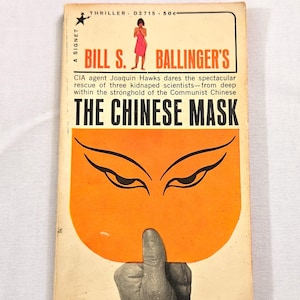 May include: Vintage paperback book titled "THE CHINESE MASK" by Bill S. Ballinger. The cover features an orange mask design with black eyes and a hand holding it. The book is a thriller.