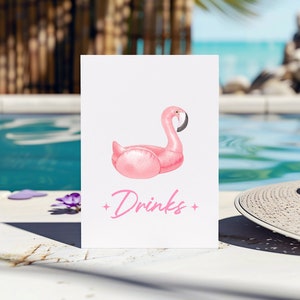 Puede incluir: Una tarjeta blanca con una ilustración de un flotador de piscina de flamenco rosa y el texto "Drinks" en letras rosas.