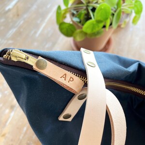 This image shows the leather zipper pull with engraved initials.