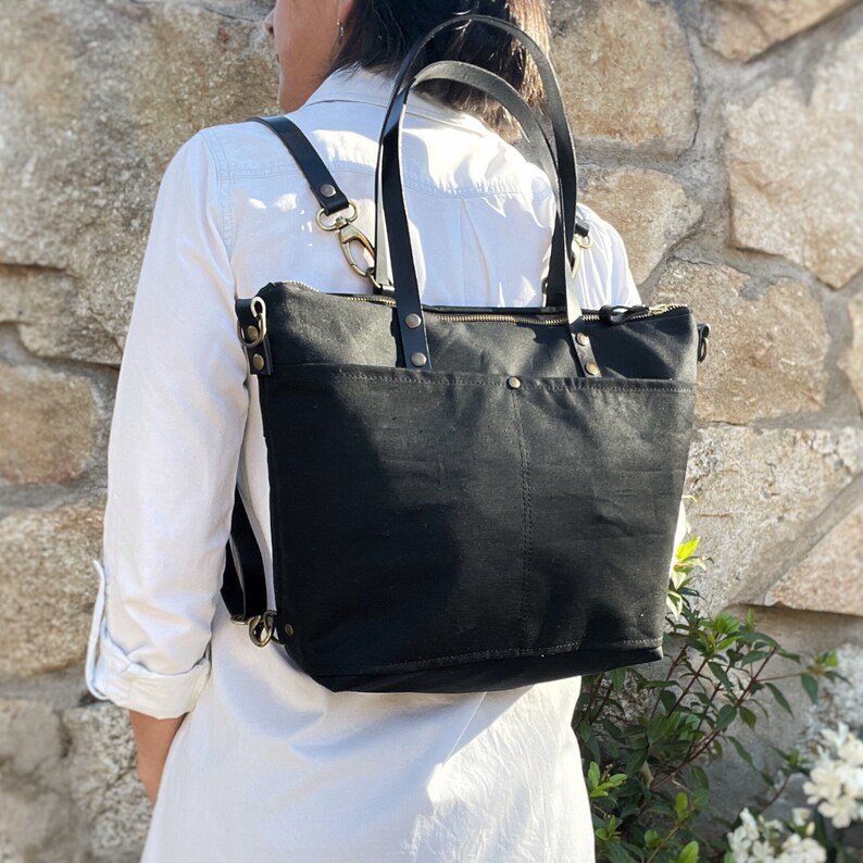 A woman wears the bag on her back with the backpack straps, while the tote handles are not in use.